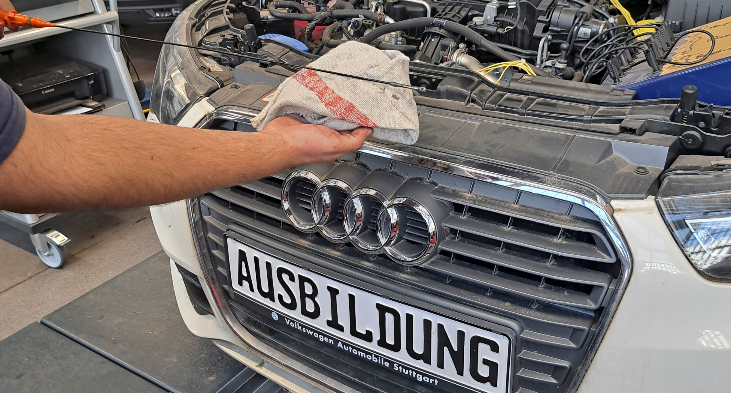 Eine Person führt Arbeiten an einem PKW durch